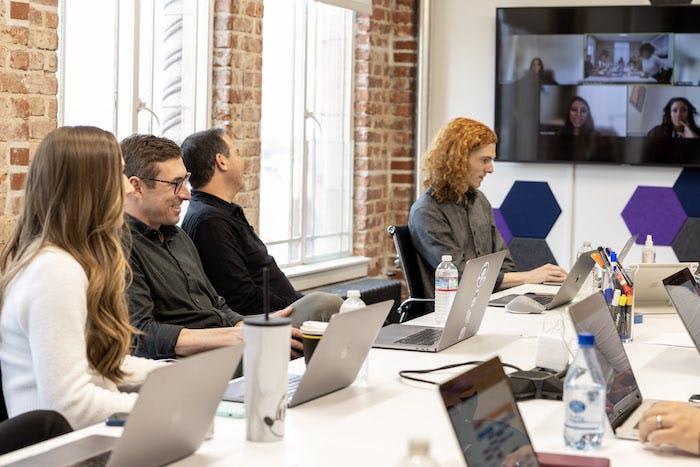 group of people in office at meeting with laptops