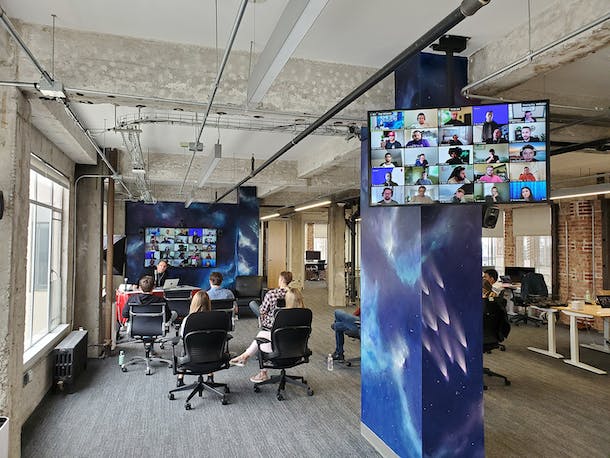 group of people in office listening to a speaker during a meeting